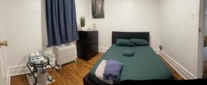 a bedroom with a green bed and a table at Banlieue Pillars Maison in Mount Vernon +31 photos