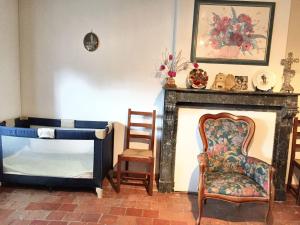 a living room with a chair and a fireplace at Maison charmante à Clairfayts avec terrasse accueillante in Clairfayts