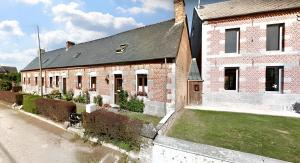 a brick building with a grass yard in front of it at Maison charmante à Clairfayts avec terrasse accueillante in Clairfayts