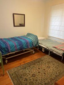 twee bedden in een kamer met een spiegel en een tapijt bij Golden Bouy in Point Lonsdale +4 foto's