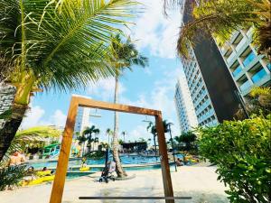 a resort with a pool with palm trees and buildings at Apto Premium Resort in Salinópolis