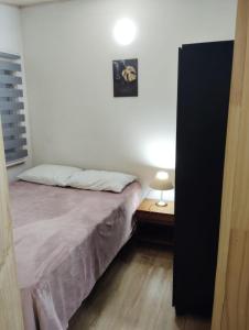 a bedroom with a bed and a lamp on a table at Cabaña interior en barrio residencial in Puerto Montt