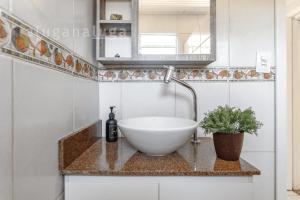 a bathroom with a bowl sink and a mirror at Casa pé na areia SC - Espaço completo in Guaporanga +36 photos