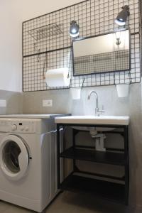 a bathroom with a sink and a washing machine at Trulli Mirabilis in Cisternino +38 photos