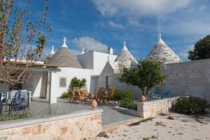 a house with a patio with chairs and turrets at Trulli Mirabilis in Cisternino