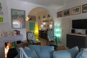 a living room with a couch and a table and a television at Trulli Mirabilis in Cisternino