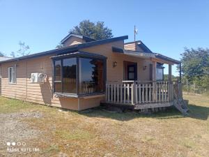 a small house with a porch and a deck at Cabaña Familiar Mirador De La Chacra 1-7 personas in Castro