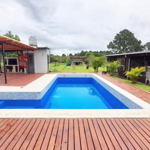 a swimming pool with a wooden deck and a playground at Casa Quinta Tambo in Garupá
