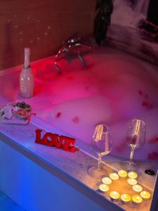 una vasca idromassaggio con due bicchieri di vino e candele di La dolce sosta ad Acerra