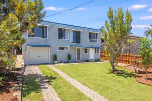 a house with a garage and a yard at Kaimai House in South West Rocks +13 photos
