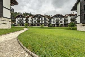 una fila di condomini con un prato di South Mountain Apartment a Razlog