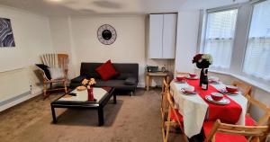 een woonkamer met een tafel en een bank bij Pier Reflections sea front apartment Long and short stays Groups and Contractors welcome in Eastbourne