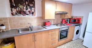 een kleine keuken met een spoelbak en een magnetron bij Pier Reflections sea front apartment Long and short stays Groups and Contractors welcome in Eastbourne +6 foto's