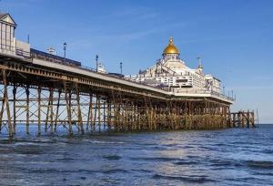 een pier met een gebouw erop in het water bij Pier Reflections sea front apartment Long and short stays Groups and Contractors welcome in Eastbourne