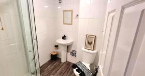 een witte badkamer met een wastafel en een toilet bij Pier Reflections sea front apartment Long and short stays Groups and Contractors welcome in Eastbourne