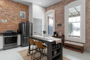 a kitchen with a table and a refrigerator at Chic Downtown Getaway - Fireplace & Soaking Tub - by Cross-Key Vacation Rentals in Millersburg