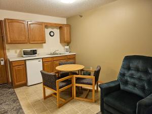 a small kitchen with a table and a chair at Budget Host Inn & Suites in Escanaba