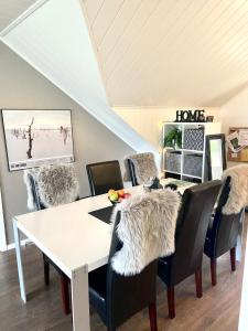 a dining room with a white table and black chairs at Large and great loft in scenic surroundings in Alta