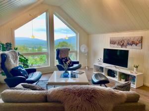 a living room with a couch and chairs and a tv at Large and great loft in scenic surroundings in Alta