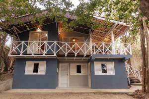 una casa azul con balcón en la parte superior en primeira vista pipa, en Pipa