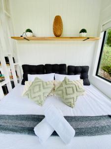 a bed with two white socks on top of it at SUNRISE at Heartland in Huonbrook +14 photos