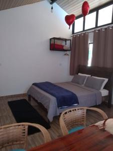 a bedroom with a bed and two chairs and a table at Chalé Primavera em Gonçalves in Gonçalves