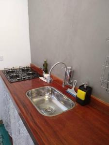 a kitchen counter with a sink and a stove at Chalé Primavera em Gonçalves in Gonçalves
