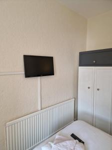 a bedroom with a tv on the wall and a bed at Winston House Guesthouse in Bridlington