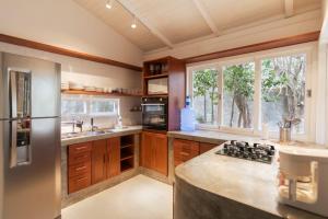 Una cocina con gabinetes de madera y un refrigerador de acero inoxidable. en primeira vista pipa, en Pipa