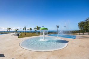 a fountain with a green umbrella in the water at Holiday Inn Ponce & El Tropical Casino by IHG in Ponce