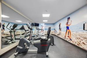 a gym with treadmills and people on the beach at Holiday Inn Ponce & El Tropical Casino by IHG in Ponce