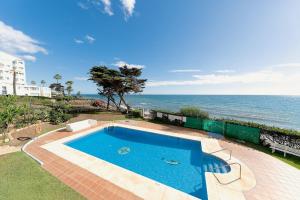 a swimming pool with the ocean in the background at ROSE I Vistas and direct access to the sea Mijas Costa in Málaga
