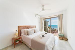 a bedroom with a bed with a view of the ocean at ROSE I Vistas and direct access to the sea Mijas Costa in Málaga +27 photos