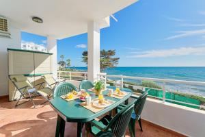 a table and chairs on a balcony with the ocean at ROSE I Vistas and direct access to the sea Mijas Costa in Málaga