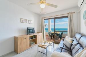 a living room with a couch and a television at ROSE I Vistas and direct access to the sea Mijas Costa in Málaga
