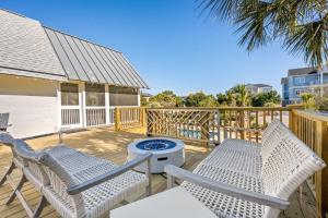 a patio with two chairs and a grill on a deck at High Seas in DeBordieu Colony home by Peace Vacations in Georgetown