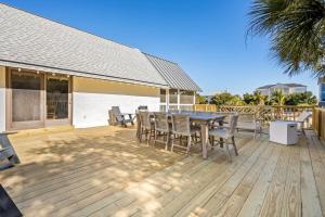 a wooden deck with a table and chairs on it at High Seas in DeBordieu Colony home by Peace Vacations in Georgetown