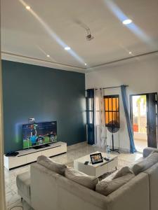a living room with a couch and a flat screen tv at Luxury 2 in Avédji