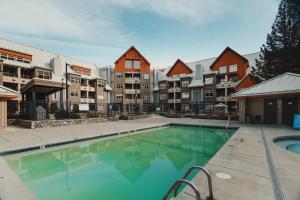 a swimming pool in front of a apartment complex at Ski-in/Ski-out Intentionally Designed Ski Lodge in Whistler
