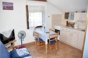 a kitchen with a table and chairs in a room at Sea View Apartment in Prvić Luka, 46m², Terrace in Prvić Luka