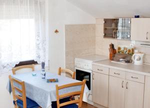 a kitchen with a table with chairs and a table and a stove at Sea View Apartment in Prvić Luka, 46m², Terrace in Prvić Luka