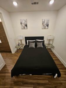 ein Schlafzimmer mit einem schwarzen Bett und zwei Lampen in der Unterkunft lavish apartment downtown in Houston