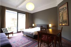 ein Schlafzimmer mit einem Bett und einem Tisch sowie ein Esszimmer in der Unterkunft Baeten's bed and breakfast in Gent