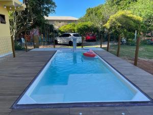 a pool with a toy in the middle of a yard at Casa de Praia Itacimirim Bahia - Piscina e Conforto in Camacari