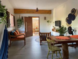 a living room with a wooden table and chairs at Casa de Praia Itacimirim Bahia - Piscina e Conforto in Camacari