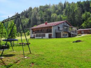 a swing set in a field in front of a building at Maison isolée et calme à Septmoncel avec vue sur montagne in Septmoncel