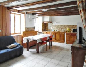 a kitchen with a table and a couch in a room at Maison isolée et calme à Septmoncel avec vue sur montagne in Septmoncel +11 photos