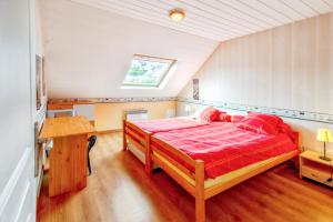 a bedroom with a red bed in a attic at Appartement charmant avec vue sur la mer - Saint-Pol-de-Léon, 60m² in Saint-Pol-de-Léon