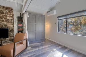 a living room with a chair and a window at Waterfall House-Riverfront-Bbq-sleeps Four in Oakhurst +17 photos