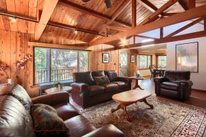 a living room with leather furniture and a wooden ceiling at Tranquility House-Riverfront-Fireplace-Sleeps six in Oakhurst +20 photos